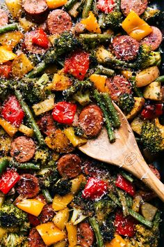 a skillet filled with sausage, broccoli and peppers