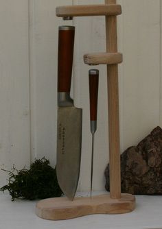 a wooden stand with two knives and a knife holder attached to the side of it