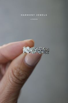 a person holding a diamond ring in their hand with the words harmony jewels on it