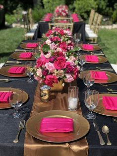 the table is set with pink and gold place settings