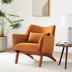a living room with an orange chair and potted plant