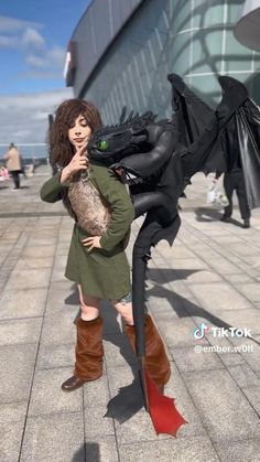a woman in boots is posing with a dragon
