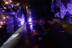 there are many pieces of paper on the floor in front of purple walls with lights