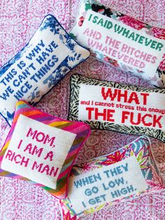 three pillows with different sayings on them sitting next to each other in front of a pink background
