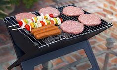 hamburgers and hot dogs are cooking on the grill