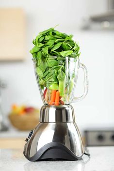a blender filled with vegetables on top of a counter