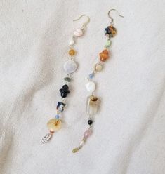 two long beaded necklaces on a white cloth