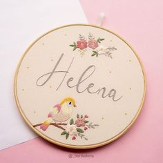 a cross stitch hoop hanging on a pink and white wall
