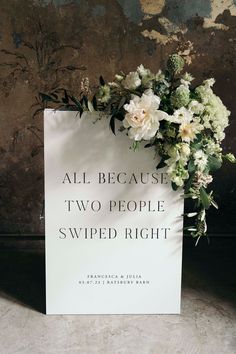 an all because two people swipeed right sign with flowers on it in front of a wall