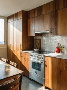 a kitchen with wooden cabinets and stainless steel stove top oven in the middle of it