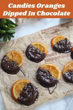 candies oranges dipped in chocolate on a piece of parchment paper