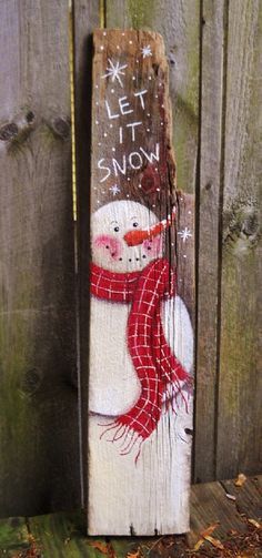 a wooden sign with a snowman painted on it