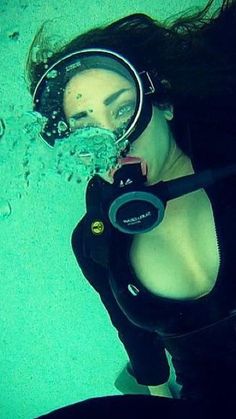a woman wearing a scuba suit and snorkels in the water