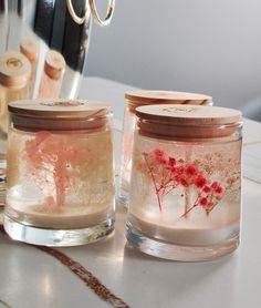 two jars filled with liquid sitting on top of a table