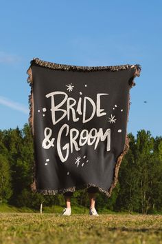 a bride and groom sign hanging from the side of a black banner with white writing on it