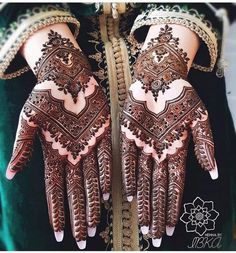 the hands and arms of a woman with henna designs on their palms, showing intricate details
