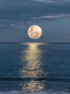the full moon shines brightly in the sky above the ocean water as it reflects on the surface