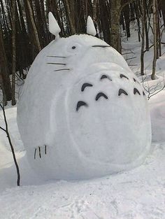 there is a snow sculpture in the shape of a totoro with eyes drawn on it