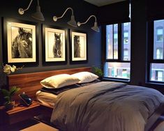 a bed sitting under three framed pictures on the wall next to a window in a bedroom