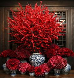 red flowers in vases sitting on a table next to an ornate screen with the words statement bouquet tips we answer your questions about floral arrangements