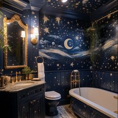 a bathroom decorated in blue and gold with stars on the ceiling, toilet and bathtub