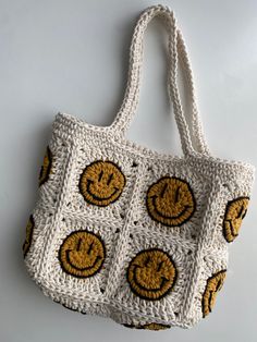 a crocheted bag with smiley faces on it