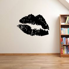 a room with a book shelf and a wall sticker that has black lipstick on it