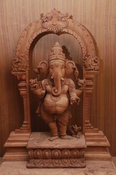 an elephant statue sitting on top of a wooden stand