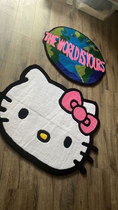 two hello kitty rugs sitting on top of a wooden floor next to each other