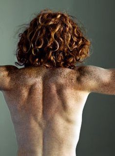 the back of a man's body is shown in this image, with no shirt on