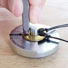 a person is using a small tool to attach something on top of a wooden table