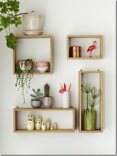 three wooden shelves with plants and pots on them in front of a wall mounted planter