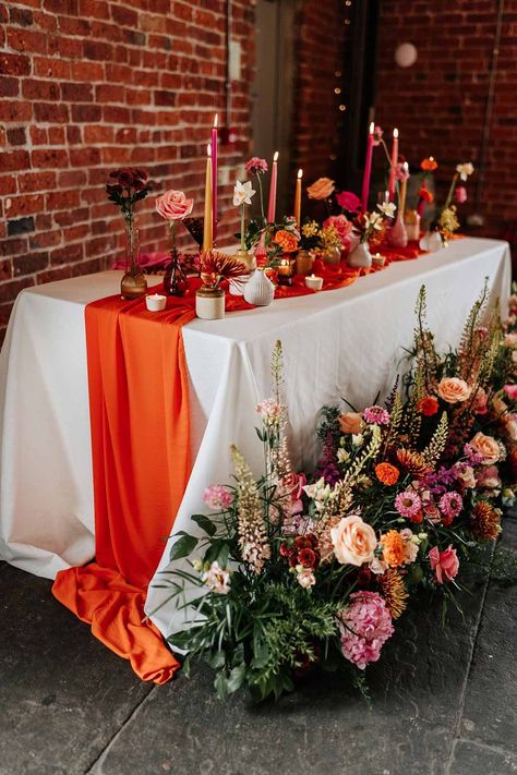 Retro wedding tablescape with pink tapered candles, orange table runner, mismatched single flower vases, colourful flower centrepieces and large colourful flower arrangements at Northern Monk Refectory Leeds | Stephanie Butt Photography Pink, Wedding Table Decorations, Wedding Decor, Wedding Tablescapes, Wedding Table Settings, Wedding Table Decoration, Orange Wedding Decorations, Table Runners Wedding, Table Flowers