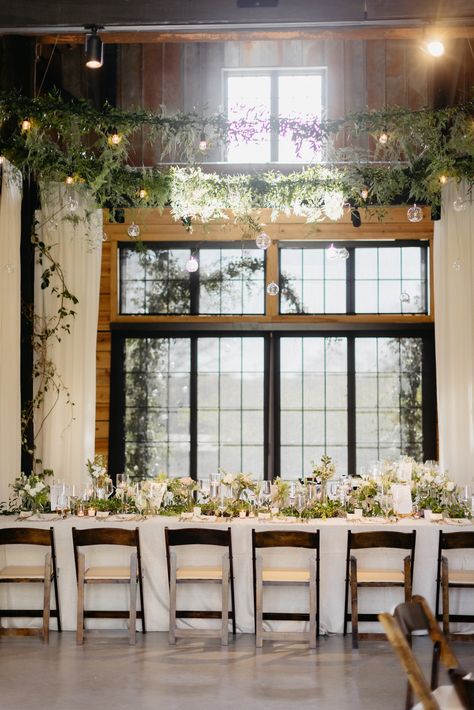 Taking a blank canvas barn, and completely transforming it into your dream wedding reception. Hanging greenery and market lights to set the vibe of the night. Hanging white drapery for that elegant feel, long family style dining with the reception layout, a mix of banquet style tables and rounds with greenery and white florals with pillar candles in the center of the tablescape. Open barn doors giving your guests the ultimate view of open land. Wedding Receptions, Tables, Layout, Home, Dream Wedding, Wedding, Barn Wedding, Dream Wedding Reception, Wedding Reception