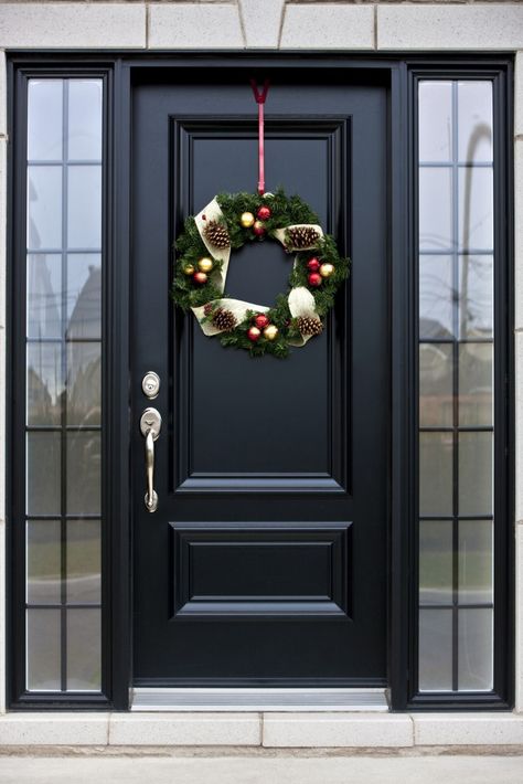 Here's a truly bespoke black door, with silver hardware, flanked by a pair of smoked glass windows.