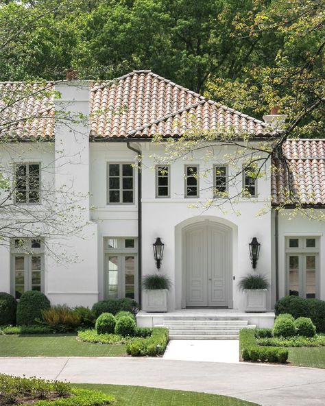 The front exterior of a white house with orange spanish tile shingles and a beautifully manicured green lush lawn Interior, Exterior, Naples, White Stucco Exterior, White Stucco House, Terracotta Roof House Exterior Colors, Tile Roof House Exterior Colors, Red Tile Roof Exterior Paint Colors, Stucco House Colors