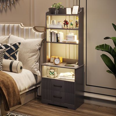 This multifunctional nightstand brings modern convenience and ample storage to your bedroom. Made from engineered wood, it features two drawers with ribbed fronts and three open shelves for organizing your essentials. The built-in LED lights offer three color options - white, warm, and blue - with adjustable brightness to suit your mood. What sets this nightstand apart is its multiple charging stations, including two standard outlets, a USB port, and a Type-C port to keep your devices charged an Bookshelves, Home Décor, Home, Tall Nightstands, Bookshelf Nightstand, Bedside Table, Bedside Table Design, Bookshelf Next To Bed, Wood Nightstand