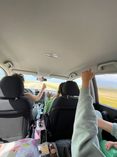 In a car with my three friends with are hands in the sky.