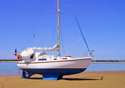 A Macwester 27 sailboat, sitting perfectly on her bilge keels and skeg-hung rudder on a beautiful sandy beach. Yachts, Popular, Sailboat Cruises, Sailboat Living, Liveaboard Sailboat, Liveaboard Boats, Small Sailboats, Yacht Boat, Sailboat Interior