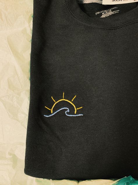 Hand embroidered black sweatshirt with blue wave and sun. I made this as a christmas present for my sister and she loves it. I did a backstitch for the entire design to ensure the stitches would stay secure #embroidery #sun #wave #handmade
