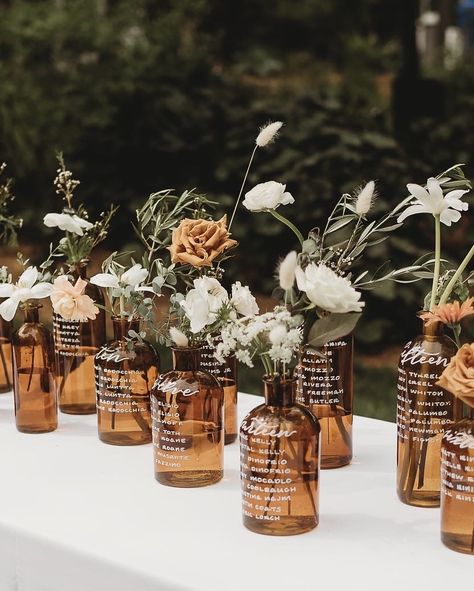 Amber glass bottles with white ink calligraphy for a wedding at Chatfield Hollow Farm in Connecticut. | Photo by Hayley Fitch | Calligraphy by Nob Hill Jane | Flowers by Earth Blossom Flowers Decoration, Wine Bottle Centerpieces, Glass Bottle Centerpieces Wedding, Glass Bottles Wedding, Glass Vase Wedding Centerpieces, Glass Wedding Centerpieces, Bottle Centerpieces, Wedding Glassware, Bud Vase Centerpiece Wedding