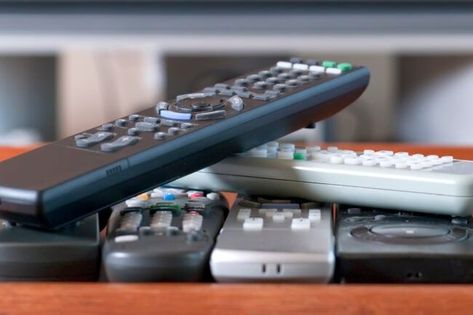 Discover a few tips on storing your television remotes in your living room. | 10 Things You Should Take Off Your Coffee Table to Declutter Tv Remote, Declutter, Tv Controller, Remote Caddy, Remote Control Holder, Remote Controls, Surround Sound Systems, Coffee Table Books, Television