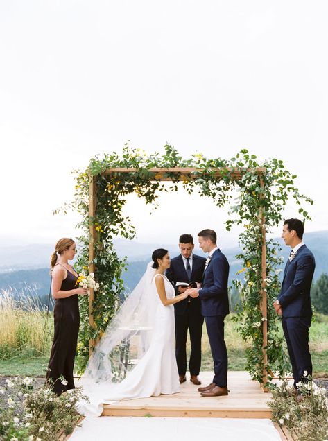 Wooden structure with greenery and wildflowers for wedding ceremony arch at Georgecrest Vineyards in Washington planned by Beth Helmstetter. Beth Helmstetter events destination wedding with wooden platform, outdoor wedding with mountain view. Inspiration, Wooden Wedding Arches, Outdoor Wedding Ceremony Arch, Wedding Arches Outdoors, Outdoor Wedding Ceremony, Ceremony Arch, Wedding Arch Greenery, Outdoor Ceremony, Wedding Ceremony Arch