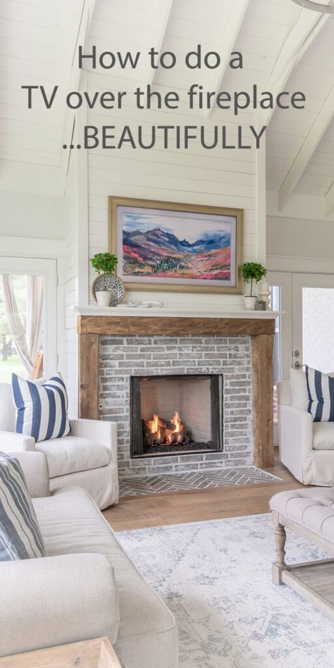A vaulted living room has a rustic farmhouse fireplace and brick tile surround, with a television mounted over it. The TV looks like a painting against a shiplap wall. The fireplace has white chairs on each side. Home Décor, Diy, Interior, Hide Tv Over Fireplace, Tv Above Fireplace, Tv Over Fireplace, Fireplace Tv, Fireplace Tv Wall, Hide Tv