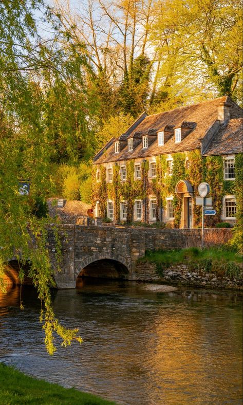 A period property in the evening sunshine behind a river and small road bridge. The spring scene is surrounded by trees that are beginning to bloom. Hotels, Country, Destinations, Urban, London England, Arlington Row, Countryside Hotel, Cotswolds Hotels, The Cotswolds England
