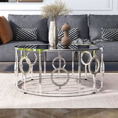 Punctuated with ring details, this glam chrome coffee table is a sleek focal point. A mirror glass top adds to the airy ambiance of the open frame. This steel base fits well in an art deco style entertainment space. Art Deco, Design, Decoration, Home Décor, Mirrored Coffee Tables, Silver Coffee Table, Round Glass Coffee Table, Mirror Glass, Round Coffee Table Living Room