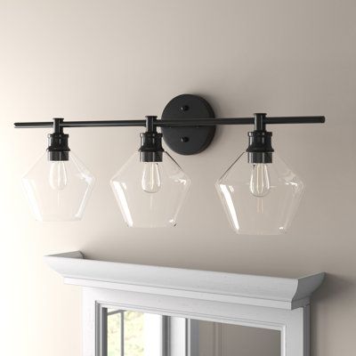 This 3-light vanity light brings contemporary appeal to your bathroom or powder room. It's made from metal and features a circular backplate with a horizontal arm that supports three geometric glass globe shades that house the 40W bulbs. We love how you can install this light facing up or downward so you can make it work in your space. Plus, you can operate this fixture with a dimmer switch. Finish: Black, Shade Colour: Clear Dressing Table, Design, Metal, Bathroom Vanity Lighting, Vanity Lights Bathroom, Black Vanity Light, Above Mirror Bathroom Lighting, Bathroom Light Fixtures, Vanity Lighting
