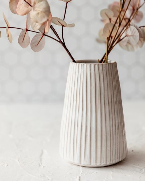 Our tall fluted vase is great for a large bunch of flowers, its textural design adds visual interest while still creating the perfect neutral backdrop to your flower arrangement.It is wheelthrown using Stoneware clay, then handcarved and glazed in white.It measures approx 17.5 cm high x 8.5 cm at t Decoration, Ceramic Pottery, Pottery Vase, Ceramics Ideas Pottery, Ceramics Pottery Vase, Ceramic Flower Pots, Ceramic Pot, Large Ceramic Vase, White Ceramic Vases