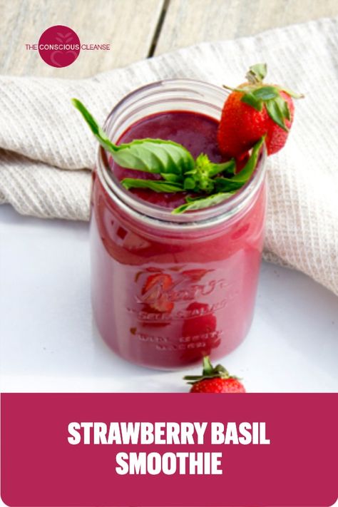 A mason jar filled with Strawberry Basil Smoothie topped with basil and sliced strawberries