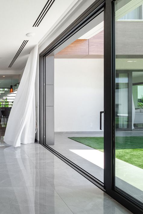 The central idea of ​​the design of this modern private house is based on the integration of the inside and outside. The large sliding doors cover the entire corner of the living room, creating freedom of space and unity with the outdoors. #aluminiumwindows #aluminiumdoors #modernkitchen #modernlivingroom #modernarchitecture Sliding Door Design, Aluminium Sliding Doors, Modern Sliding Doors, Sliding Window Design, Sliding Doors Interior, Aluminum Windows Design, Sliding Glass Door, External Sliding Doors, Sliding Doors Exterior